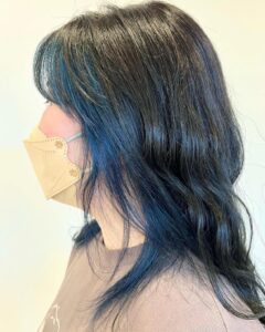ミディアムのゆる巻きヘア。ビビットな青色インナーカラーと暗めのグレーが相性抜群です